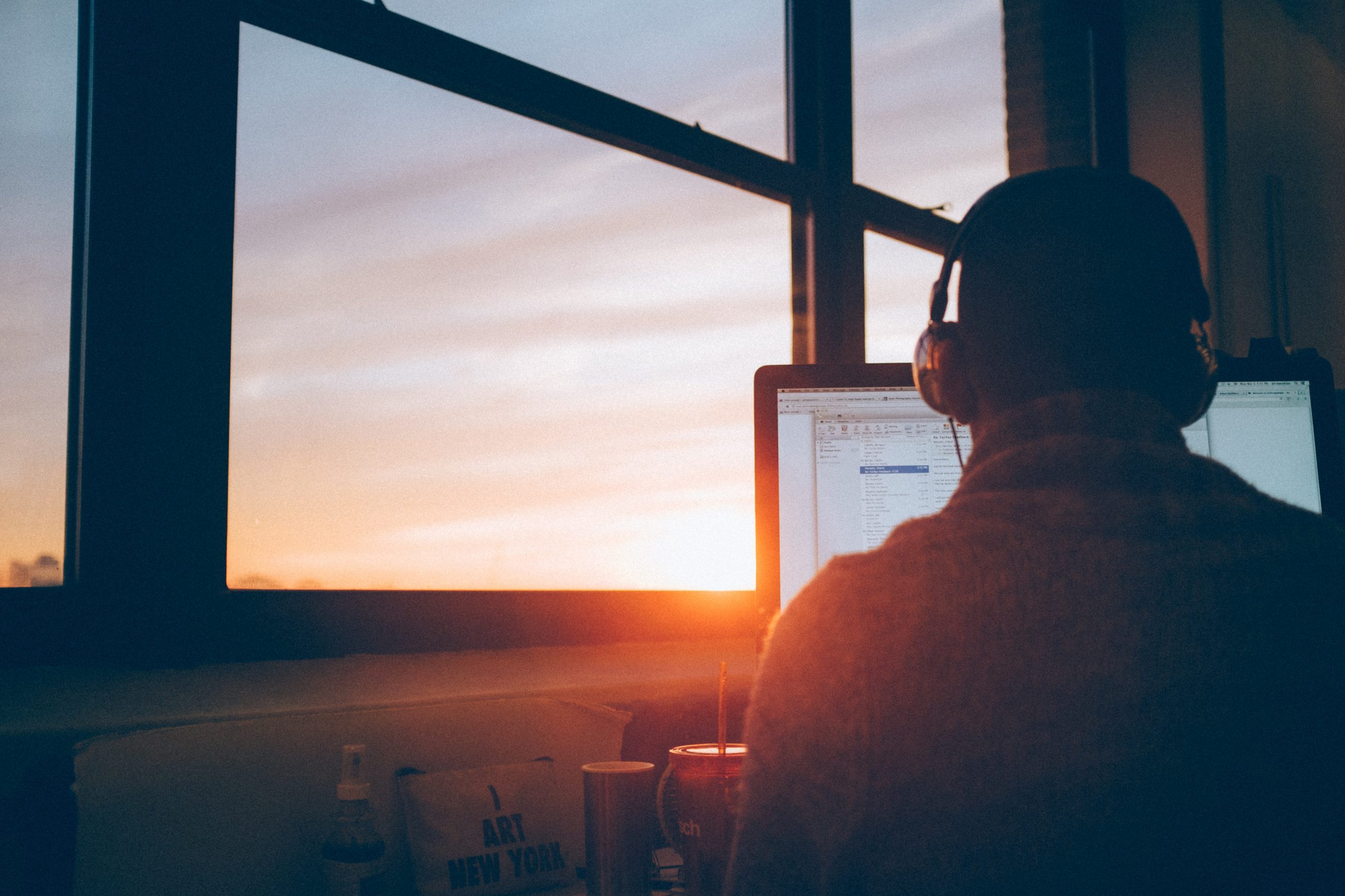 a man in headphones working near the window